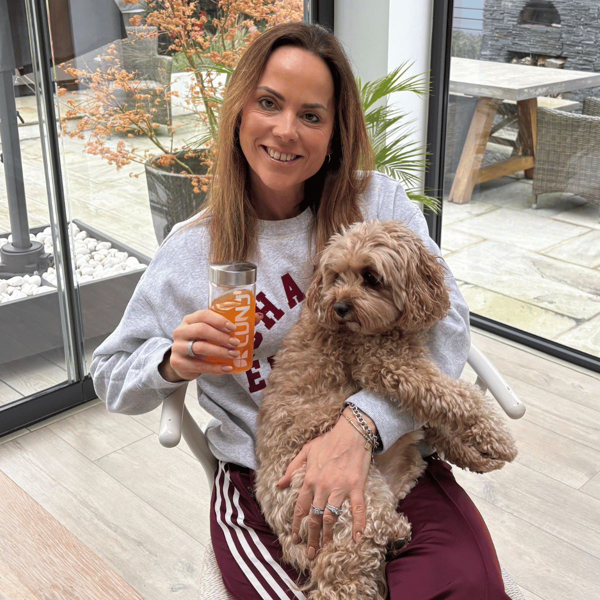 Happy customer enjoying LUNJ FitGlo® drink at home with her dog