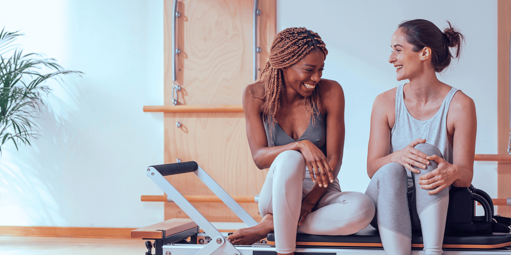 Woman exercising on a reformer Pilates machine during a wellness workout